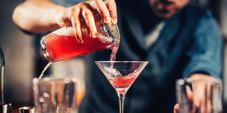 A guide to rolled up holiday pay in 2024. Bar tender topping up a summer cocktail